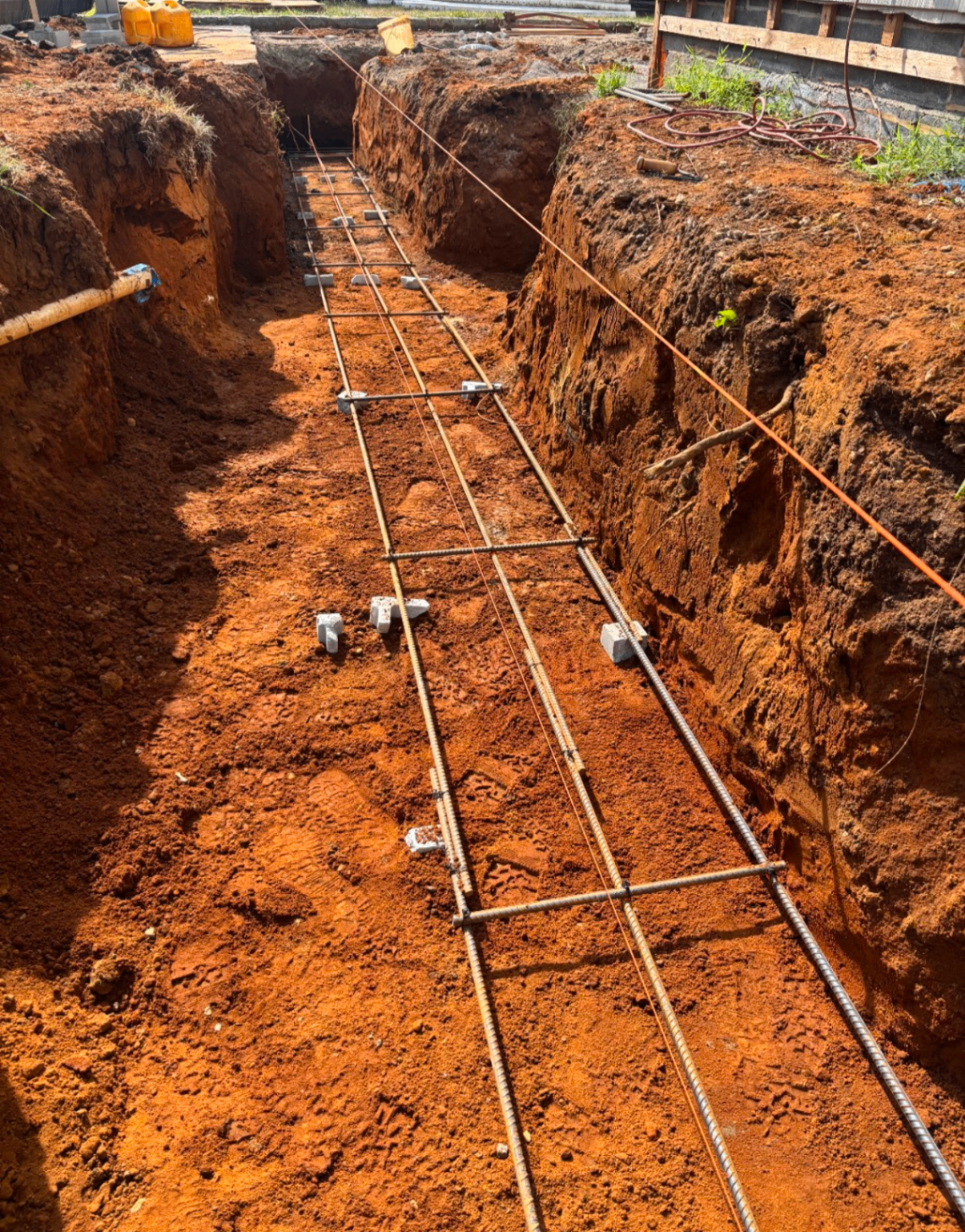 Excavated footing trench with rebar cage ready for concrete pour